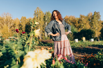 Woman celebrating the simple joys of rural life with open arms in her garden. Autumn day of contentment: Woman enjoying her garden and sustainable lifestyle