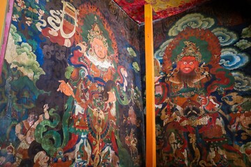 Vibrant wall paintings inside Drepung Monastery, Lhasa, Tibet, depicting colorful deities and intricate Tibetan Buddhist art rich in cultural and spiritual symbolism.