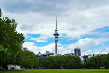 Naklejka premium A Scenic View of the Sky Tower Amidst Green Trees and Urban Landscape Under a Cloudy Sky in Auckland, New Zealand, Showcasing Beautiful Nature and Architecture