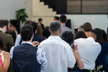 wedding ceremony celebrating marrage, with a wedding party crowd taking photos and videos of the party dancing and watching