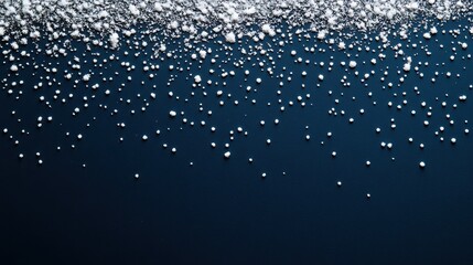 An abstract representation of falling snow using white dots on a solid navy blue background