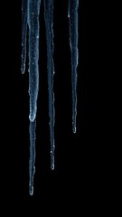 Icicles glisten in the darkness of a black background, winter scene, seasonal
