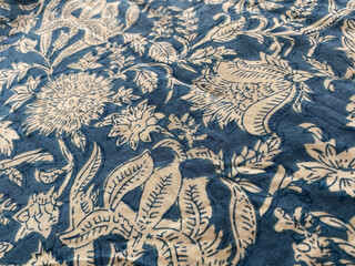  cLose up blue indigo cotton fabric showcases an intricate white floral outline, creating a...