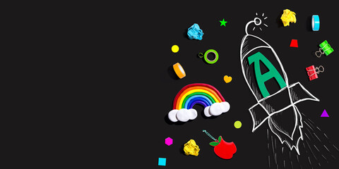 Obraz premium Back to school theme with a letter A rocket with school supplies - Flat lay