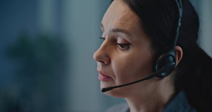 Modern call center office of mental health line: Close up of Caucasian hotline specialist in headset talking to person, consulting online, providing psychological assistance and emotional support.
