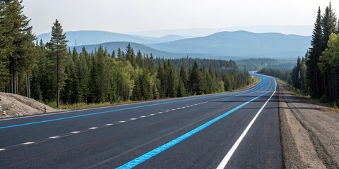 Naklejka premium A long stretch of asphalt highway with a white lane and blue road markings, surrounded by trees and a distant mountain range, travel, country road, drive