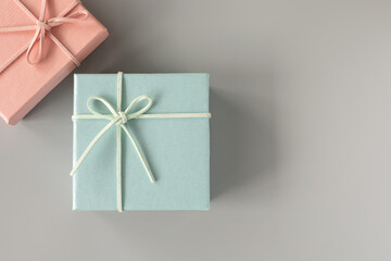 Top view, flat lay with copy space of blue gift box and pink over grey background. Gift box for concept for happy birthday, thank you, congratulation, mother's day, anniversary, Valentine's day.