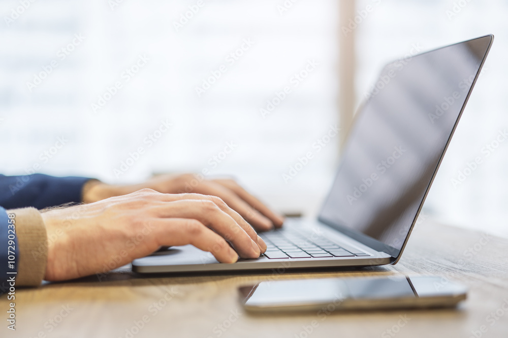 Poster the image shows a close-up of a man's hands typing on a state-of-the-art laptop keyboard, with an of