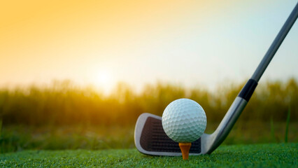Golf clubs and balls on a green lawn in a beautiful golf course with morning sunshine.