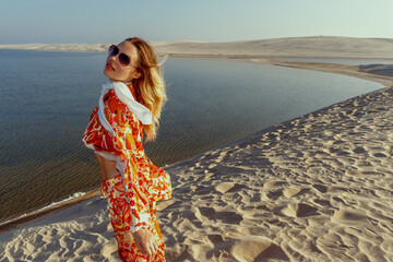 A girl poses on the dunes in the "Inland Sea" of Khor Al Adaid in the rays of the setting sun in Qatar