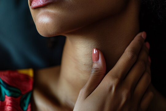 Close up of black woman holding hand to throat