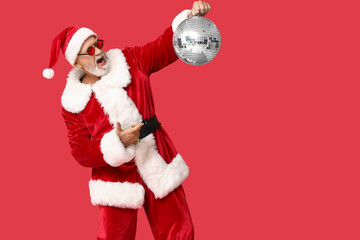 Santa Claus in sunglasses pointing at disco ball screaming on red background