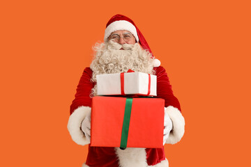 Santa Claus with Christmas gifts on orange background