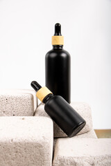 Matte Black Dropper Bottle on Stone Blocks for Minimalist Skincare and Beauty Branding