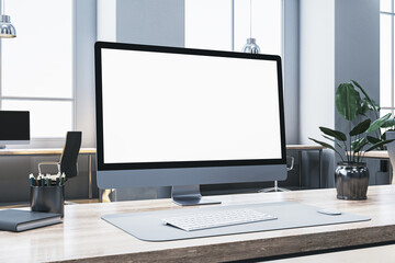 Fototapeta premium Modern computer screen with blank display on an office desk, clean workspace, and plants in a well-lit room. 3D Rendering
