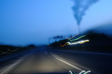 Obraz premium Light trails on the highway at dawn, smoke from a chimney, swaying, long exposure / 明け方の高速道路のライトの軌跡 煙突から出る煙 振れる 長時間露光