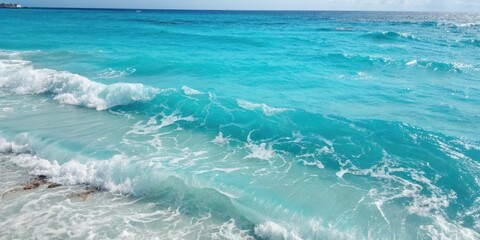 Fototapeta premium A breathtaking wave crashing on a sandy beach, with a cerulean sky and clear, turquoise water