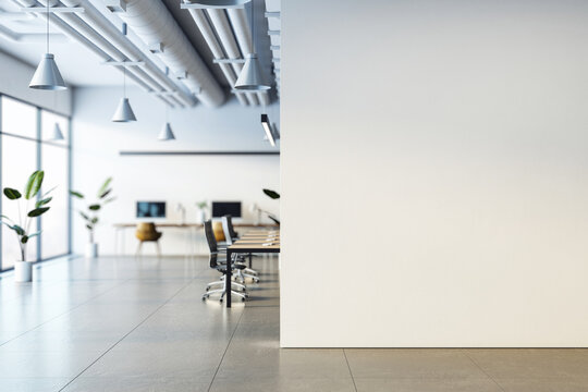 Modern office interior with desks, chairs, computers, and plants, minimalist design, focus on light and space, city view windows. 3D Rendering