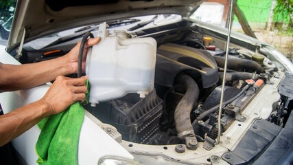 Cleaning the coolant storage tank for the car radiator that is damaged and leaking To maintain the engine system