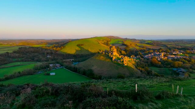 Aerial sunset view of Corfe Castle, a village and civil parish in the English county of Dorset, UK