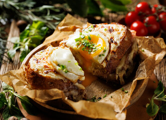 Hot croque madame sandwich cut in half, showing the yolk leaking out. A traditional French sandwich