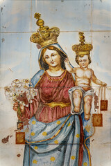 Obraz premium Mural painting on tiles of Blessed Virgin Mary holding baby Jesus Christ in her arms. ..
