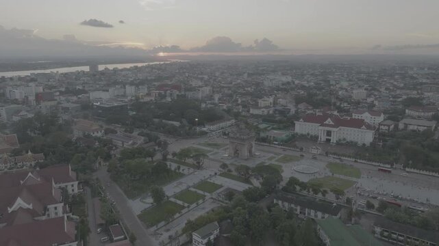 Aerial footage capturing the stunning Patuxay Monument in Vientiane, Laos, during sunset with mekong river in background (RAW D-Log)