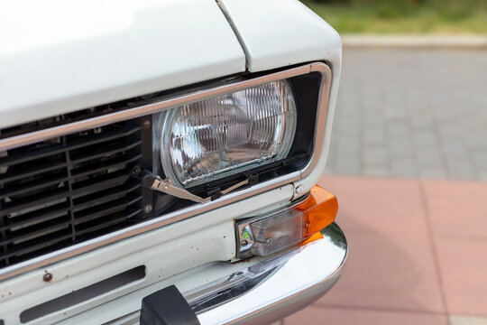 Retro car exhibition. White Moskvich-AZLK. High beam headlight with a brush, detail close-up