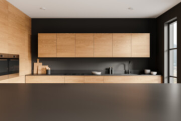 Blurred view of a modern kitchen with wooden cabinets and black countertops on a blurred background. Concept of interior design. 3D Rendering