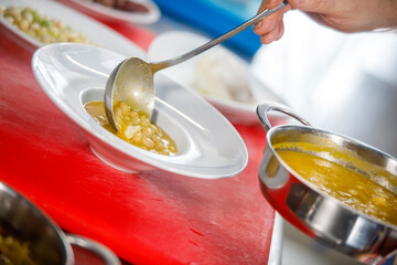 Chef is serving some white beans in a plate