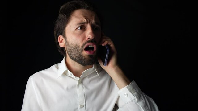 Elegant Caucasian Man is shocked after answering to a phone call