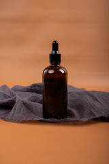 Amber Glass Dropper Bottle on Fabric Background for Skincare and Aromatherapy