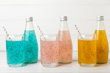 Diet detox cocktail with basil and chia seeds in a glass jar and a glass on a textured background....