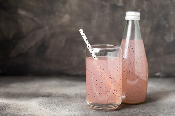 Diet detox cocktail with basil and chia seeds in a glass jar and a glass on a textured background....