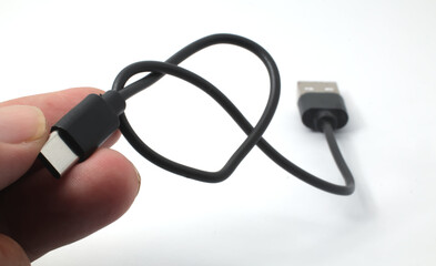 Obraz premium Hand holding USB cable near the connectors on white background.