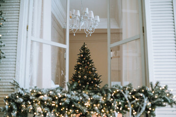 View of a decorated Christmas tree through a festive window