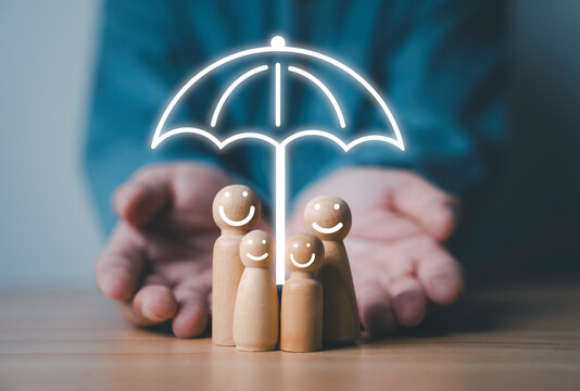 Businessman giving smile wooden figure with virtual umbrella for health lift insurance can protect in family and wellness concept.