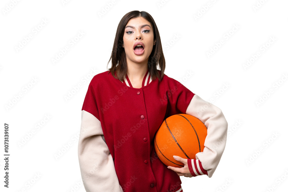 Wall mural Young Russian woman playing basketball over isolated chroma key background with surprise facial expression