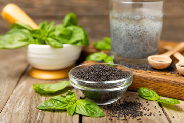 Basil seeds on textured wooden background. Close-up. Superfood. Ocimum basilicum. Organic basil seeds. selasih. Space for text. Copy space.