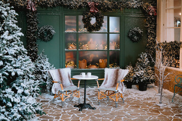 Cozy winter patio with snowy decorations and warm seating for two