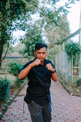 Southeast Asian man posing with a fighting stance, ready for action.