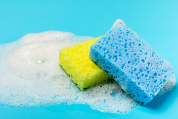 Colorful dish sponges on textured background. Kitchen sponge. Cleaning concept, cleaning service. Dishwashing liquid with clean and dirty dishes plate. Place for text, copy space. Wash the dishes.