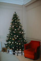 Festively decorated Christmas tree with gifts in a cozy living room corner
