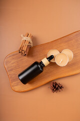 Black Dropper Bottle with Cinnamon Sticks and Tealight Candles for Cozy Aromatherapy Decor