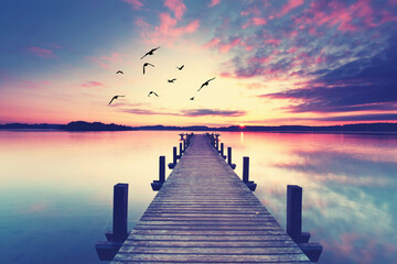 Fototapeta premium mystical and magical sunrise on the wooden pier in the calm and tranquill morning