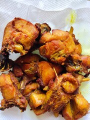 A delicious and crispy fried chicken dish cut into small pieces on an oil absorbent tissue
