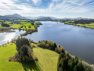 aerial landscape photo of with Lake Rottachspeicher between pastures and colorful autumn forests in the upper Allgaeu in Petersthal, next to Kempten Kempten