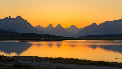 Fototapeta premium Sunset in the mountains at a calm lake - Sunset over the mountain reflection at golden hour, Calm mountain lake reflecting the sunset in the mountains, dawn