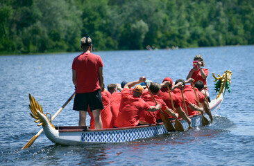 Oarsmen rowing a dragon boat on the river