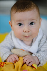 Portrait of a newborn baby. He looks at the camera and smiles. 3 months